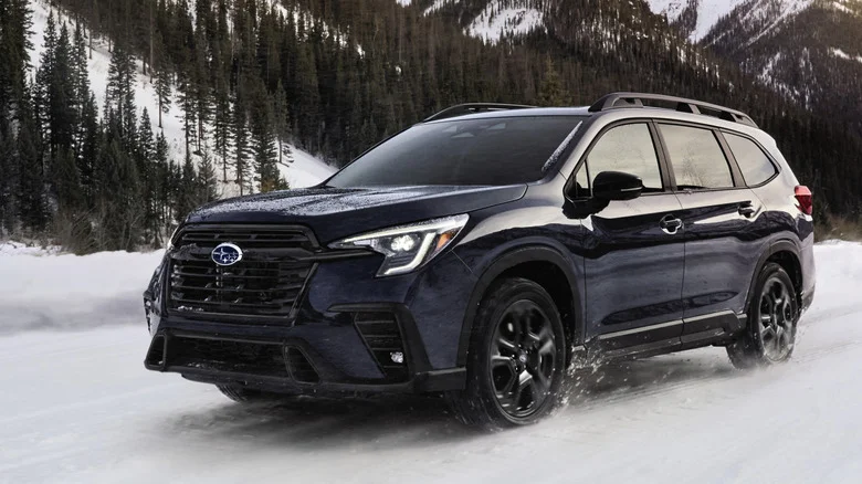 A dark blue Subaru Ascent SUV driving in the snow.