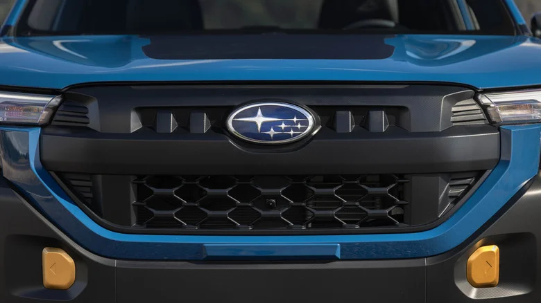 A close up of the front bumper and badge of a blue 2026 Subaru Forester Wilderness